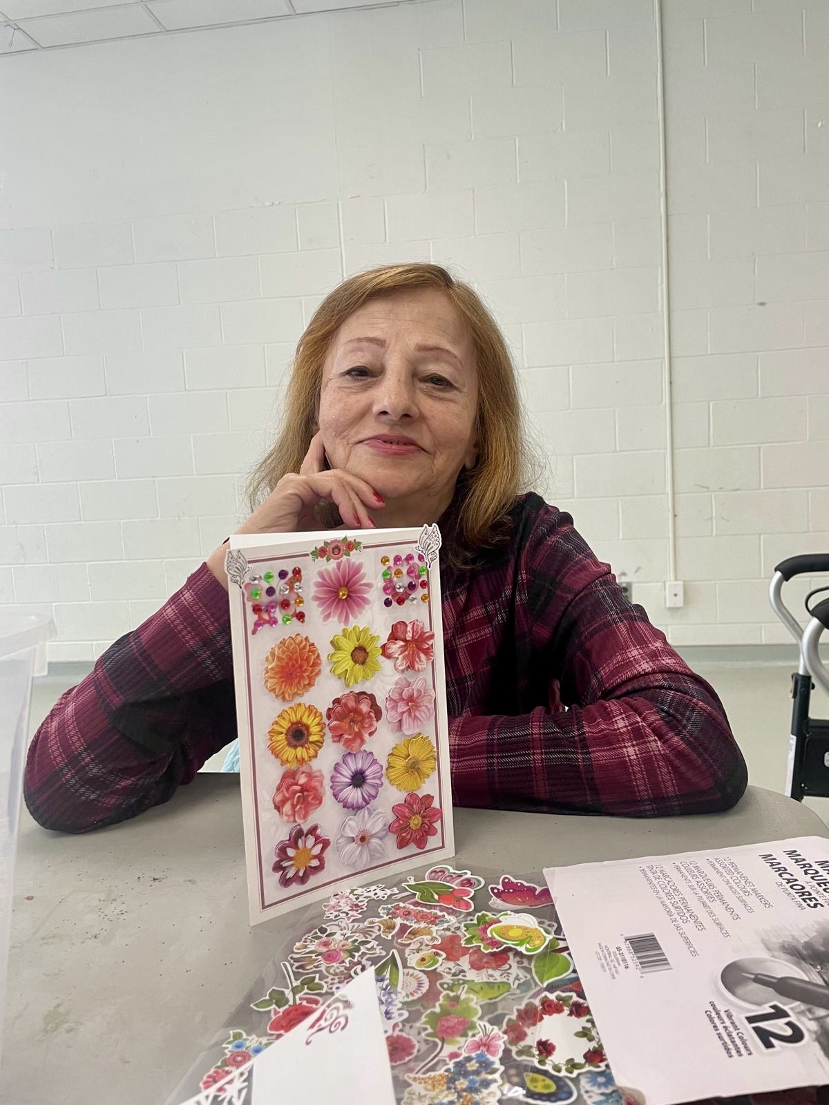 Participant smiling while showing a handmade floral greeting card